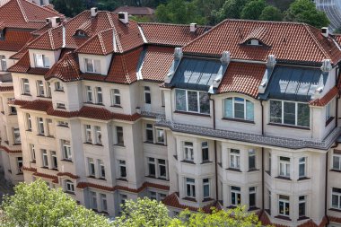 Büyüleyici mimarisi ve kırmızı kiremitli çatıları olan şık bir bina, manzaralı bir yer.