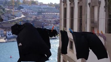 İki renkli bina arasında asılı çamaşır iplerinde kurutmak için rüzgarda sallanır ve çırpınır..