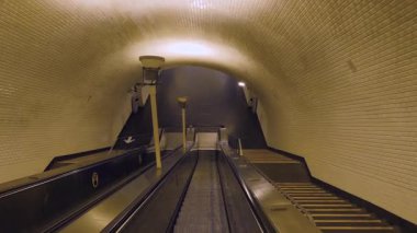 Metro tünelinde yürüyen merdiven var, hafifçe aydınlatılmış, güzel bir şekilde şehir keşfi ruhunu çağrıştırıyor.. 