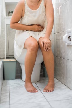 Mide enfeksiyonu geçiren ve banyoda olan bir kadının dikey görüntüsü..