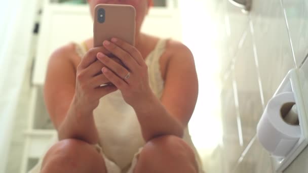Kobieta Korzystająca Telefonu Podczas Siedzenia Toalecie — Wideo stockowe