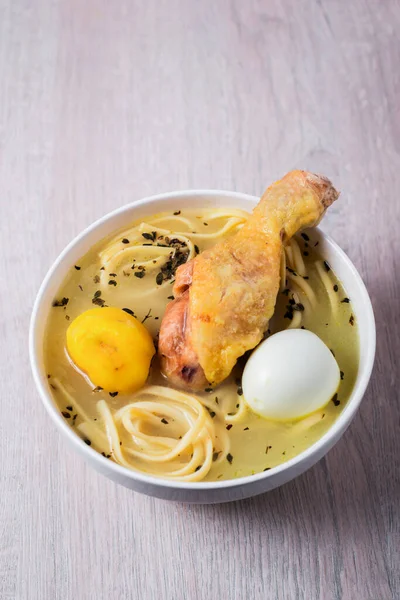 Traditional Peruvian dish with chicken, noodles, yellow potato, and hard-boiled egg.