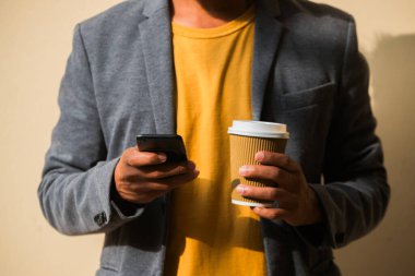 Cep telefonu ve kahvesi olan kimliği belirsiz Latin bir işadamı..