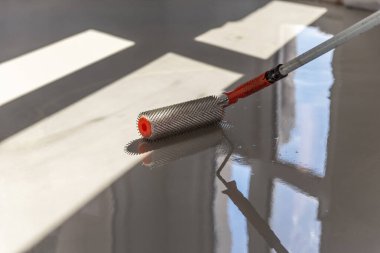 Zemini dümdüz etmek için iğne silindiri. Yerleri çimento karışımıyla döşemek..