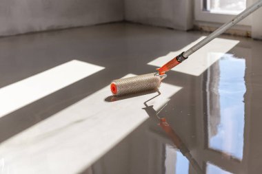 Zemini dümdüz etmek için iğne silindiri. Yerleri çimento karışımıyla döşemek..