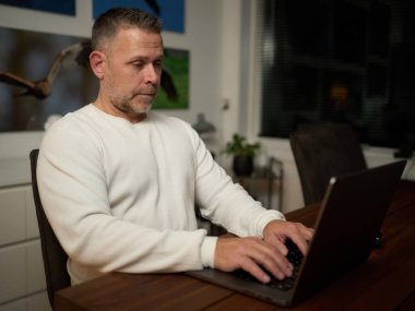 Bilgisayarda çalışan orta yaşlı bir adam.