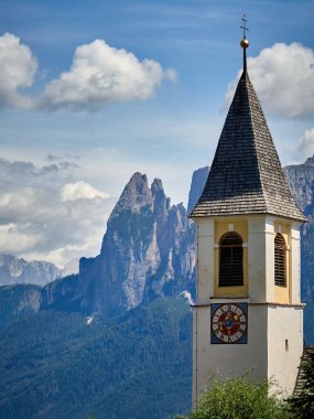 İtalya 'daki güzel ve muhteşem Dolomite dağlarının önünde bir kilise kulesi var.