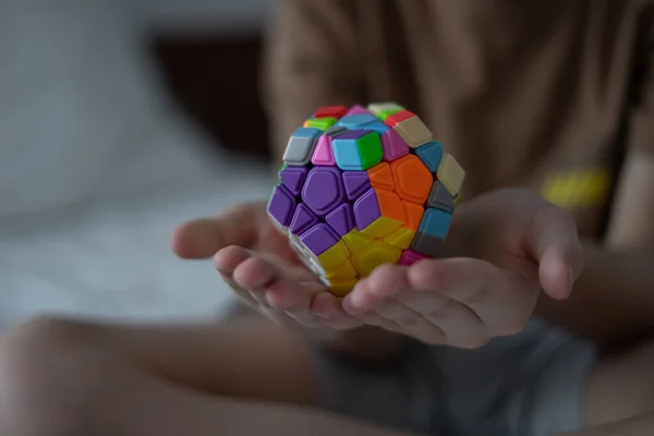 Çocuk elleri zeka, matematik ve mantıksal düşünce için renkli oyuncaklar ya da plastik 3 boyutlu bulmacalar tutar