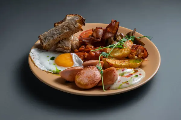 Yağda yumurta, patates, pastırma, sosis, fasulye, ekmek ve soslu tam İngiliz kahvaltısı..