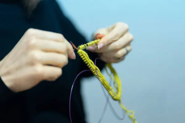 Kadın eli kesikli, atölyede örgü iğnesiyle örmeyi öğreniyor.. 