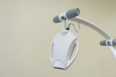 Sarı arka plandaki diş kliniğinde modern diş beyazlatma lambasına yakın çekim. Tıbbi ekipman. Reklam kavramı. 