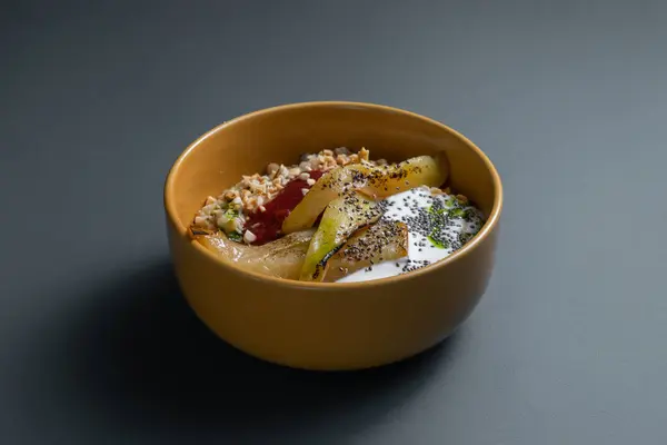 Restoran menüsünde sağlıklı kahvaltı, meyveli yulaf ezmesi, fındık ve siyah arka planda seramik kasede chia tohumları. Vejetaryen yemeği, armutlu tatlı yulaf lapası, badem, Yunan yoğurdu ve böğürtlen reçeli