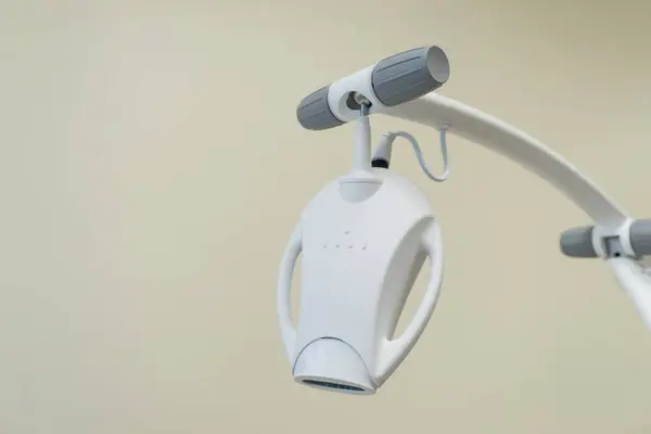Sarı arka plandaki diş kliniğinde modern diş beyazlatma lambasına yakın çekim. Tıbbi ekipman. Reklam kavramı. 