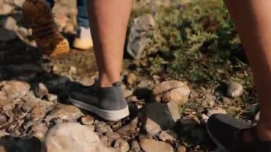 Back view of Young boy and girl walking on rocky land.