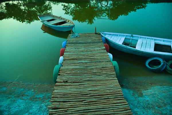 Wooden row boat . green shade. boat dock and wooden boat.