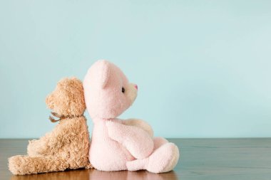 A couple of teddy bears on blue background