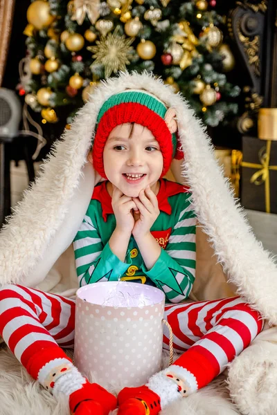 Cute Little Boy Dressed Elf Opens Christmas Present While Hiding — Stock Photo, Image