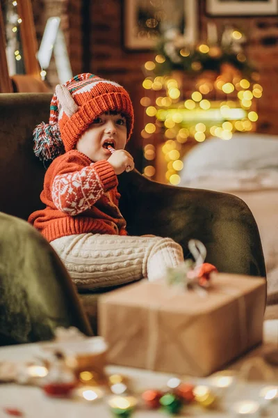 Happy Kid Sits Chair Christmas Eve Eats Christmas Candy Christmas — Stock Photo, Image