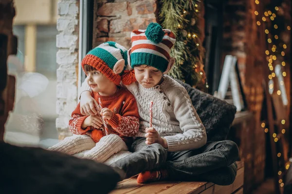 İki küçük kardeş pencerenin yanında oturup Noel Baba 'yı ve Noel Baba' yı bekliyorlar. Mutlu çocukluklar ve Noel.