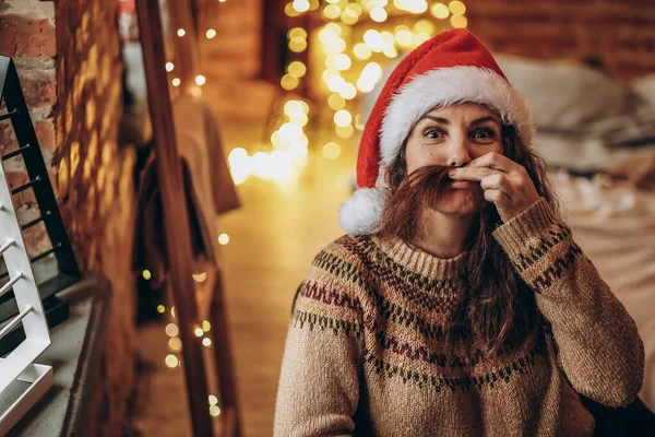 Genç bir kadın Noel arifesinde bir sandalyede oturur. Mutlu Noeller..