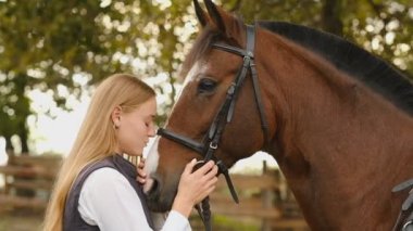 Genç bir kadın binici bir atı yarışmaya hazırlıyor. Atınızla iletişim kurun. Atlayan kadın binicilik eğitimini göster.