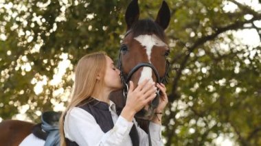 Genç bir kadın binici bir atı yarışmaya hazırlıyor. Atınızla iletişim kurun. Atlayan kadın binicilik eğitimini göster.