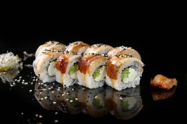 Yılan balığı, Philadelphia peyniri, salatalık, susam tohumu ve Japon restoranında hazırlanan tatlı ve ekşi soslu taze iştah açıcı suşi..