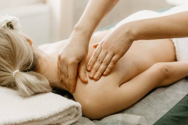 Professional doctor physiotherapist makes a back massage to a young woman. Therapeutic massage in the physiotherapist's office.