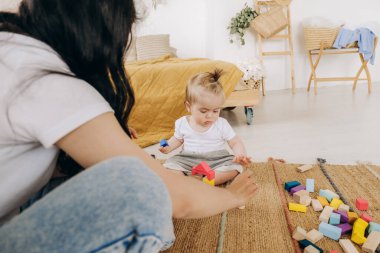Erken çocukluk gelişimi. Anne ve çocuk arasındaki iletişim. Aile içinde sevgi ve nezaket. Çocuk ahşap çevre dostu oyuncaklarla oynuyor..