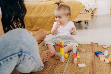Erken çocukluk gelişimi. Anne ve çocuk arasındaki iletişim. Aile içinde sevgi ve nezaket. Çocuk ahşap çevre dostu oyuncaklarla oynuyor..