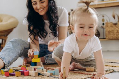 Erken çocukluk gelişimi. Anne ve çocuk arasındaki iletişim. Aile içinde sevgi ve nezaket. Çocuk ahşap çevre dostu oyuncaklarla oynuyor..
