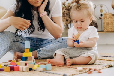 Erken çocukluk gelişimi. Anne ve çocuk arasındaki iletişim. Aile içinde sevgi ve nezaket. Çocuk ahşap çevre dostu oyuncaklarla oynuyor..