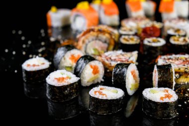 Sushi set on a black background. Fresh variety of rolls in a Japanese restaurant. Eastern cuisine.