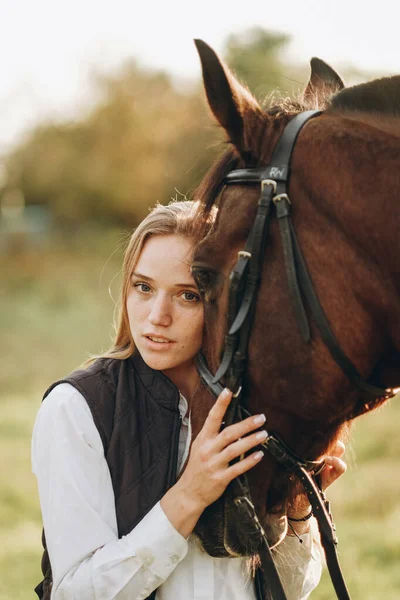 Young Beautiful Female Jockey Strokes Hugs Horse Head Prepares Competition — Zdjęcie stockowe