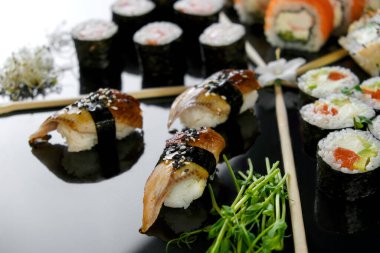 Sushi set on a black background. Fresh variety of rolls in a Japanese restaurant. Eastern cuisine.