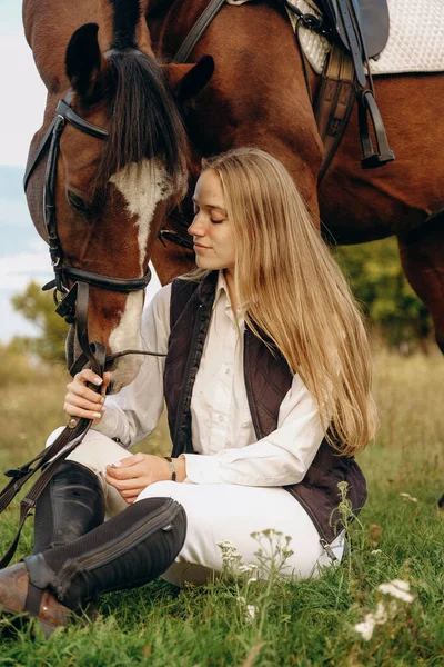 Young Beautiful Female Jockey Sits Meadow Her Horse Sunset Walk — Zdjęcie stockowe