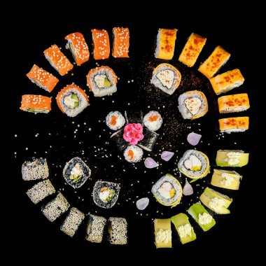 Sushi set on black background top view. Assortment of fresh mouth-watering sushi in an oriental restaurant.