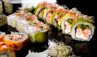 Sushi set on a black background. Fresh variety of rolls in a Japanese restaurant. Eastern cuisine.