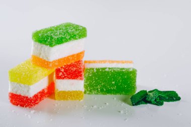 Çok renkli meyve reçeli beyaz bir masada yatıyor. Ev yapımı sağlıklı marmelat tarifi..