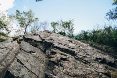 Tırmanışçılar bir iple dağın tepesine tırmanıyor..