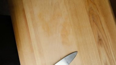 Kırmızı soğan kesme tahtasına düşer. Evde yemek pişirmek. Kırmızı soğan temizleme ve doğrama.