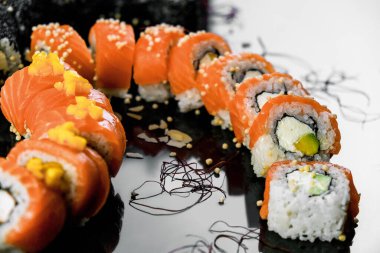 Sushi set on a black background. Fresh variety of rolls in a Japanese restaurant. Eastern cuisine.