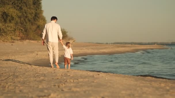 아버지는 따뜻한 가을에 해변에서 자신의 아이와 아이들의 조화로운 아이와 해변을 — 비디오