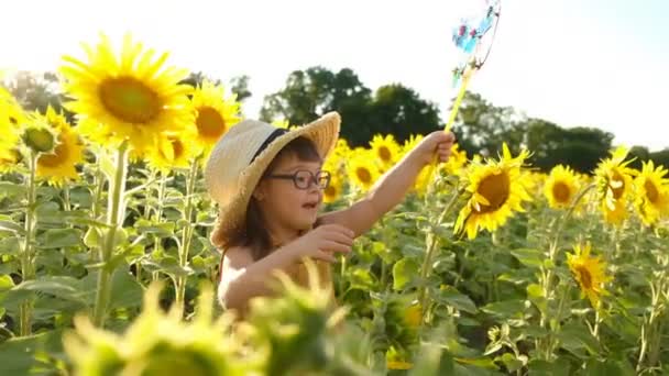 Liten Flicka Med Downs Syndrom Går Ett Solrosfält Sommaren Med — Stockvideo