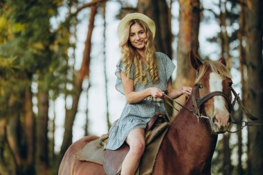 Genç ve güzel bir kadın sonbaharda ormanda ata biner. Sonbaharda akşamları ata binmek. At yarışı sporu için çiftlikte at yetiştiriyorum..