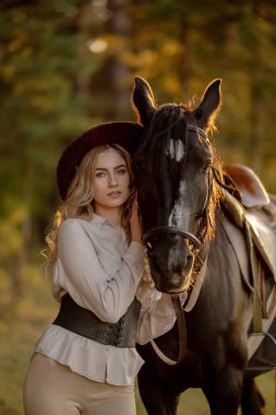 Genç ve güzel bir kadın sonbaharın başlarında atıyla ormanda yürür. Ormanda bir atla yürümek..