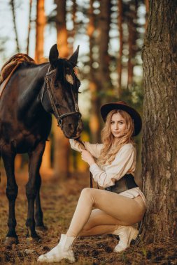 Genç ve güzel bir kadın sonbaharın başlarında atıyla ormanda yürür. Ormanda bir atla yürümek..