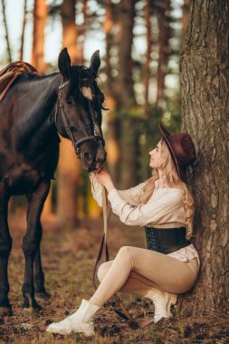 Genç ve güzel bir kadın sonbaharın başlarında atıyla ormanda yürür. Ormanda bir atla yürümek..
