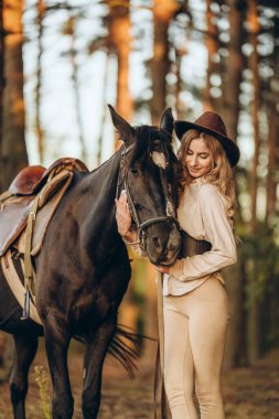 Genç ve güzel bir kadın sonbaharın başlarında atıyla ormanda yürür. Ormanda bir atla yürümek..