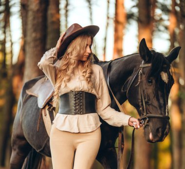 Genç ve güzel bir kadın sonbaharın başlarında atıyla ormanda yürür. Ormanda bir atla yürümek..